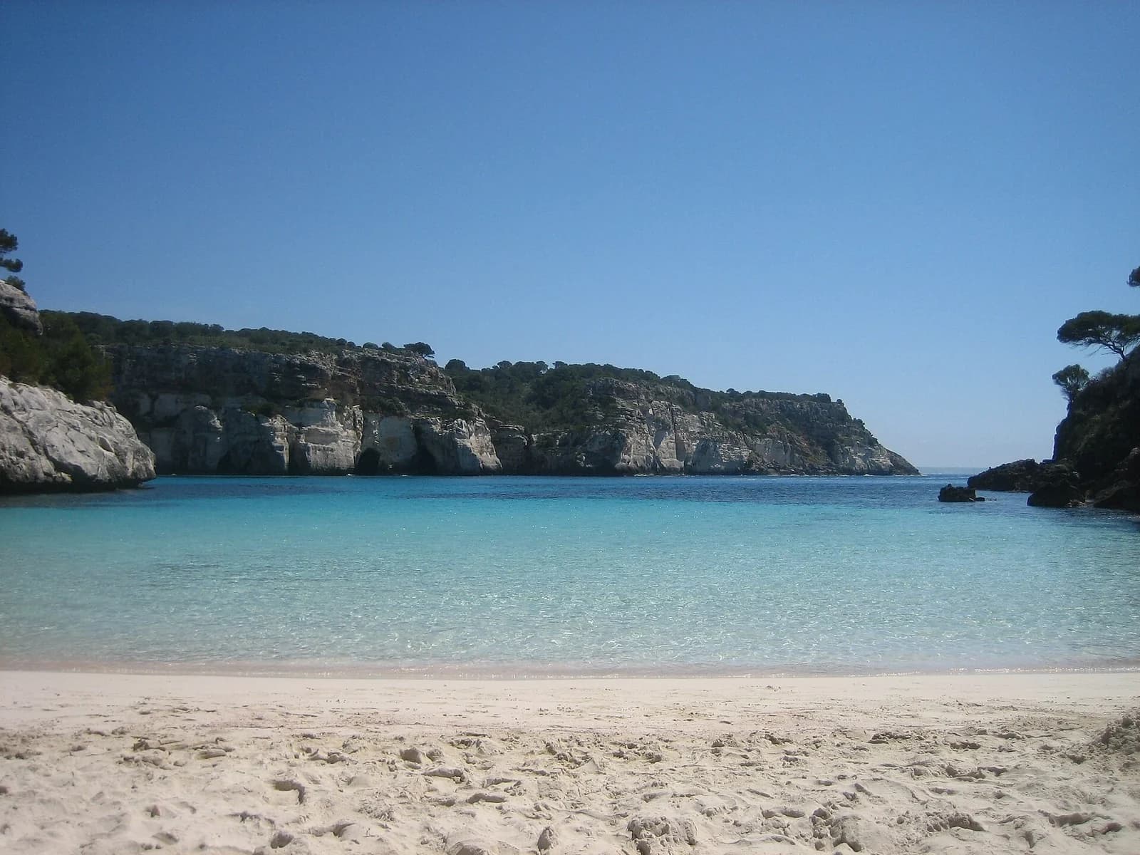 Cala Macarelleta, Menorca, Spain - turquoise shallows and white sand seen from the beach