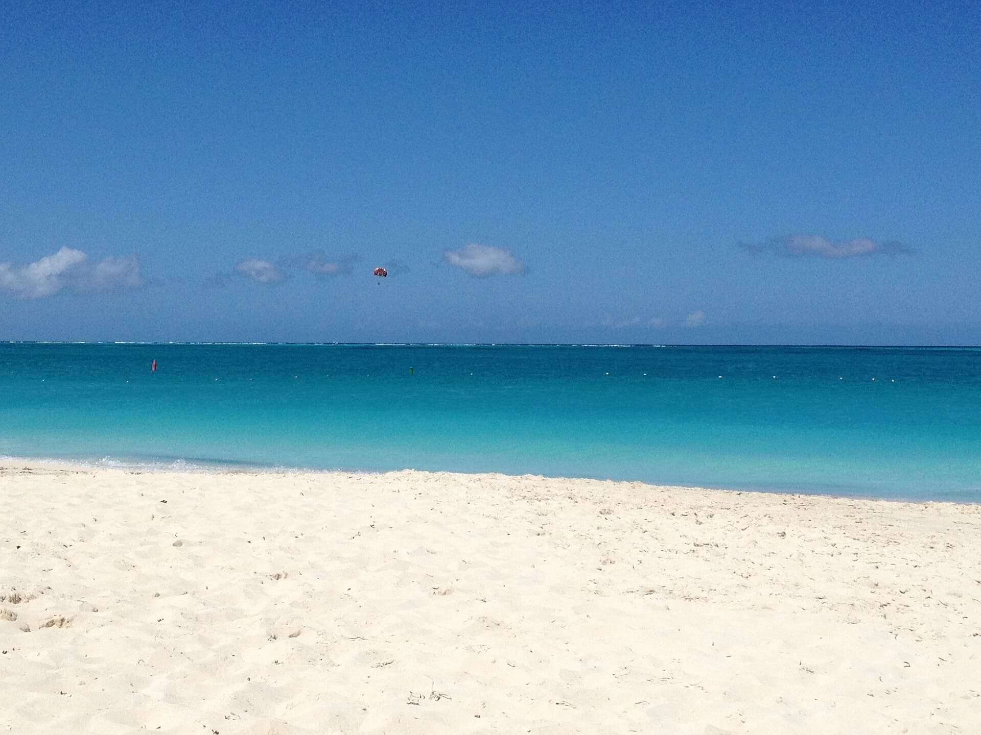 Grace Bay, Providenciales, Turks and Caicos - turquoise shallows and powder-white sand with a parasail overhead
