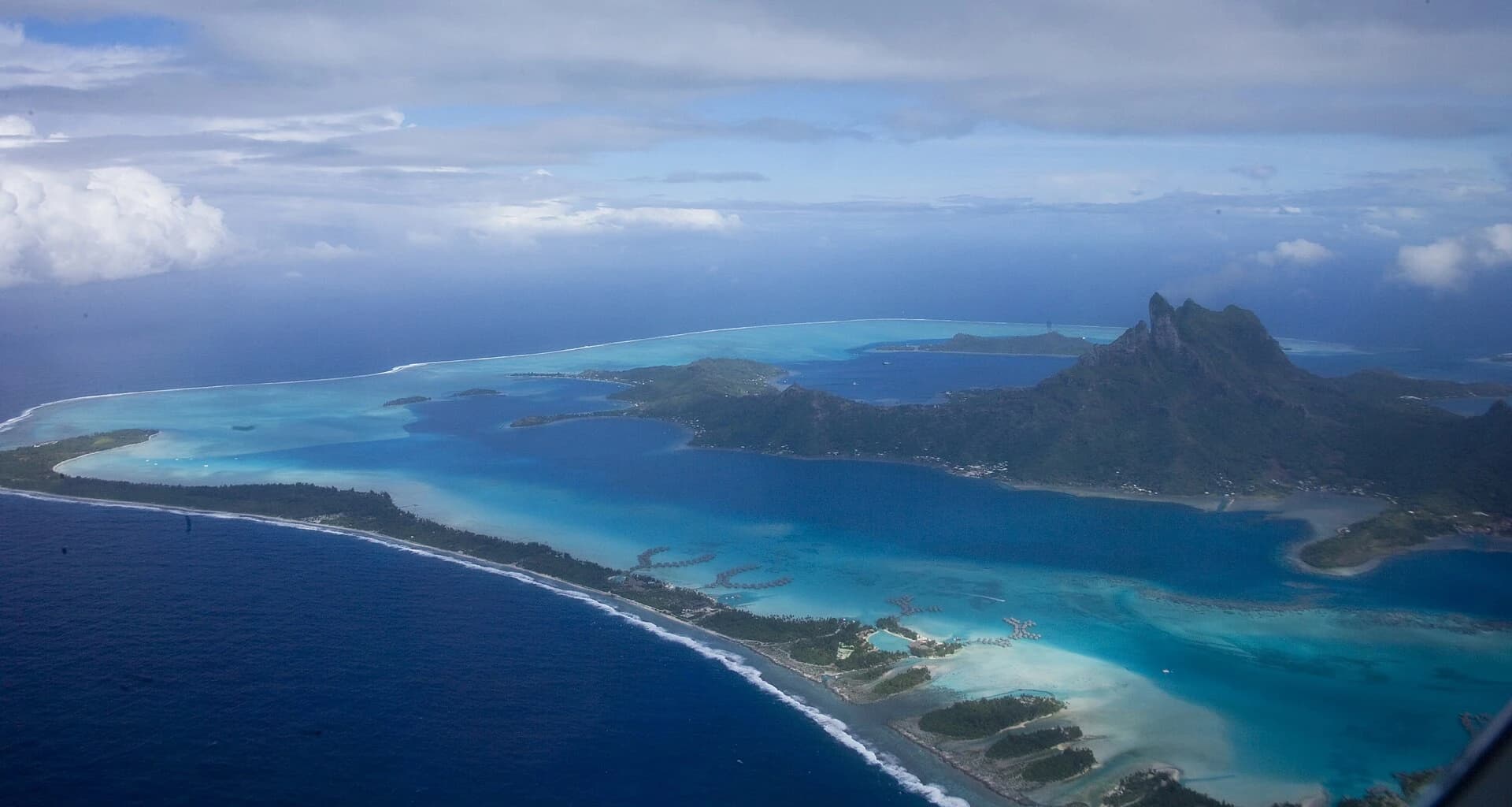 Matira Beach, Bora Bora, French Polynesia - aerial view of the island ringed by its turquoise lagoon and coral reef
