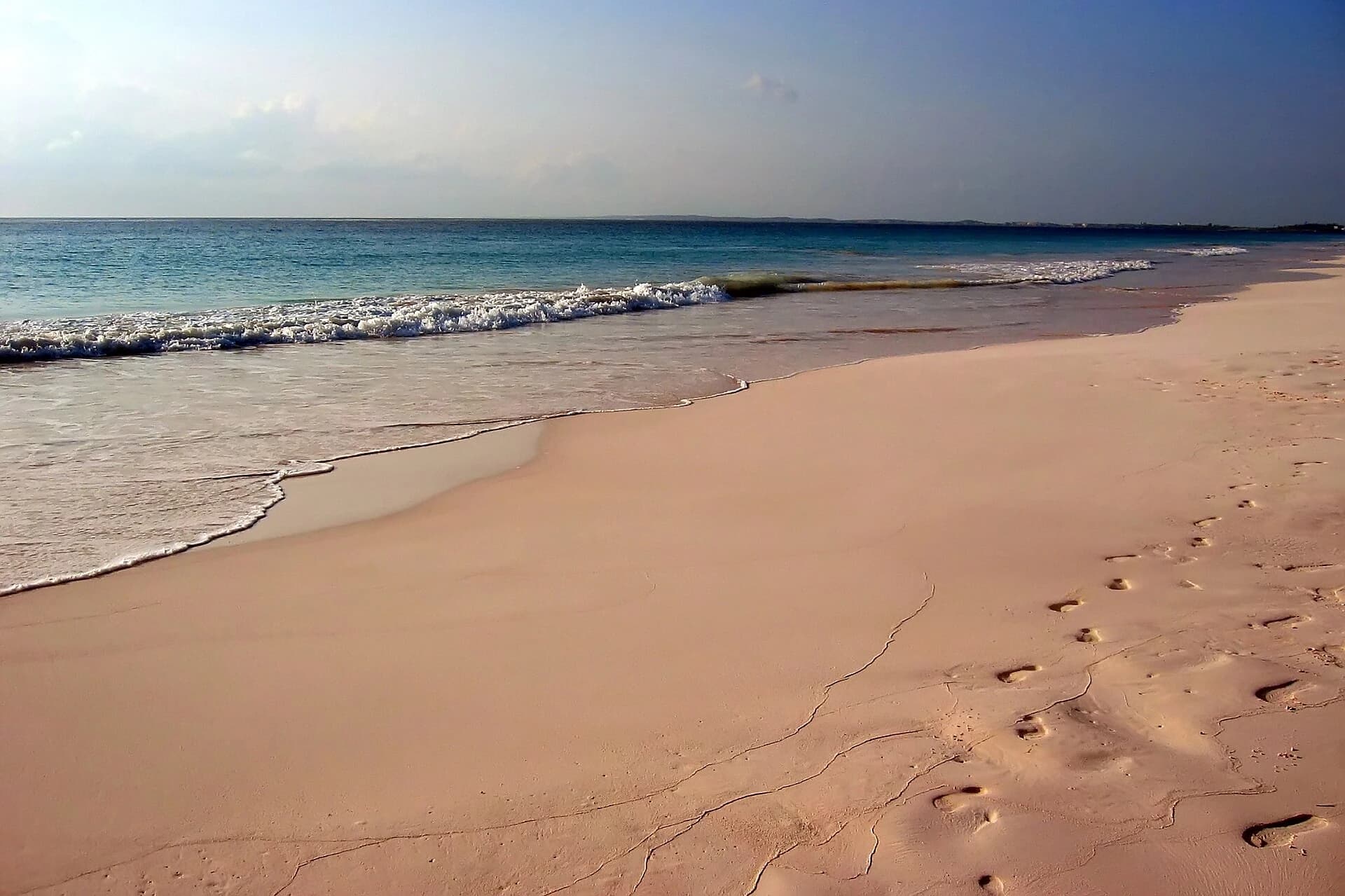 Pink Sands Beach, Harbour Island, Bahamas - pink sand and footprints beside gentle turquoise surf