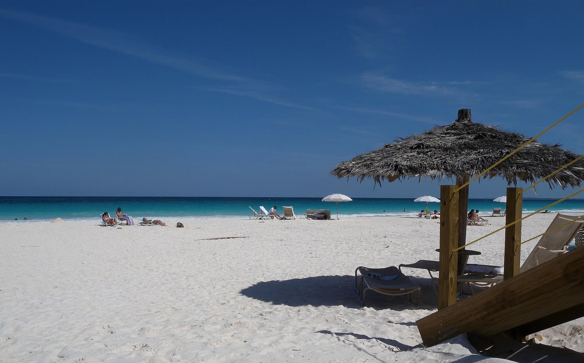 Pink Sands Beach, Harbour Island, Bahamas - sun loungers and a thatched umbrella above the turquoise shallows