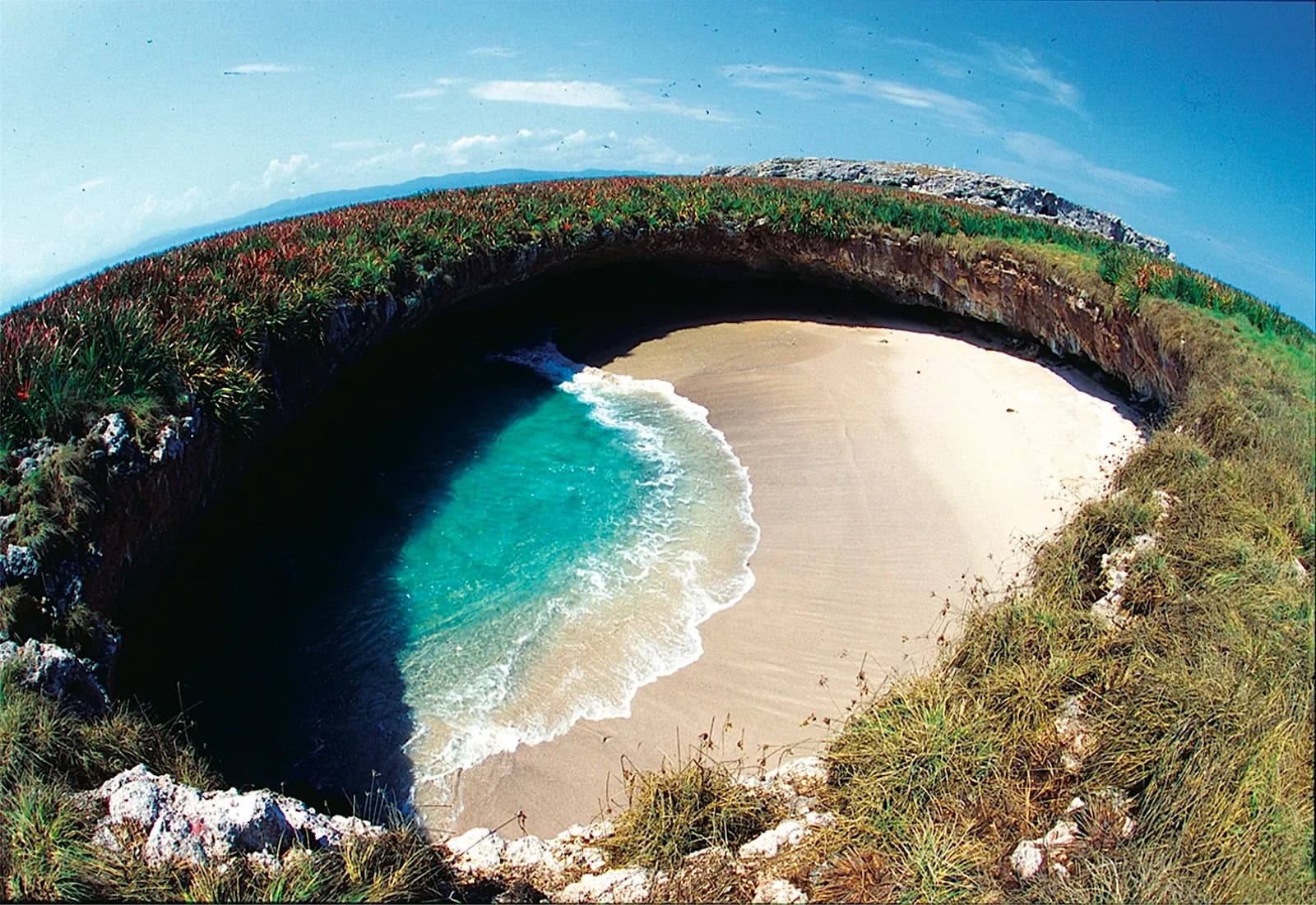 Playa del Amor (Hidden Beach), Marieta Islands, Mexico - aerial view down into the collapsed crater dome revealing the round sandy beach and turquoise water
