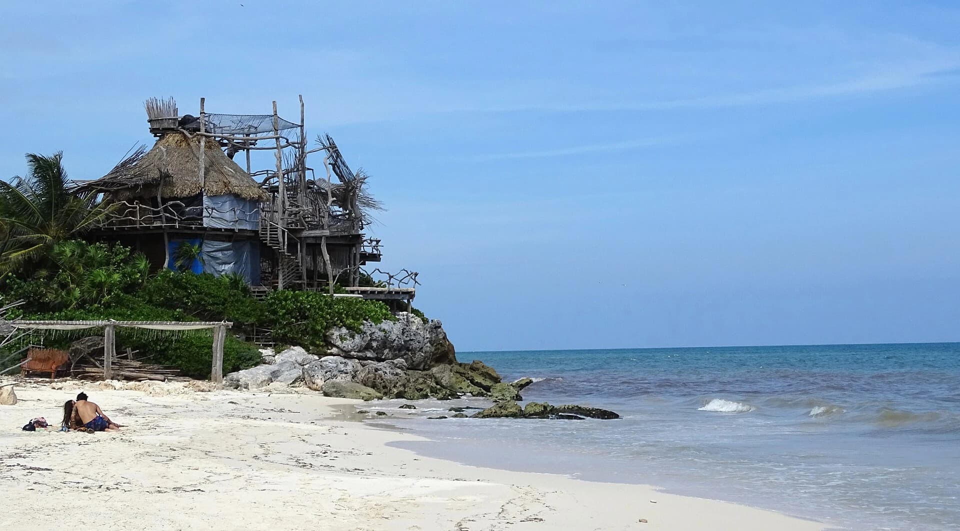 Tulum, Quintana Roo, Mexico - a thatched beach cabana on a rocky point above the sand