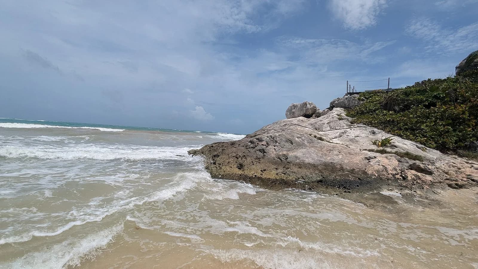 Tulum, Quintana Roo, Mexico - waves washing over a limestone outcrop on the shore