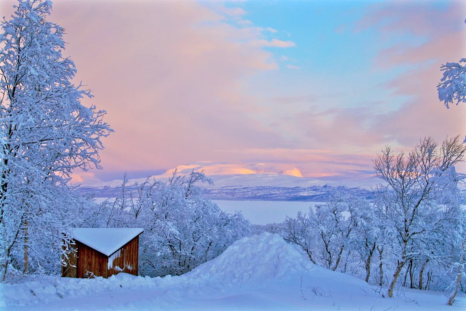 The frozen surface of Tornetrask below snow-covered mountains at Abisko in Swedish Lapland