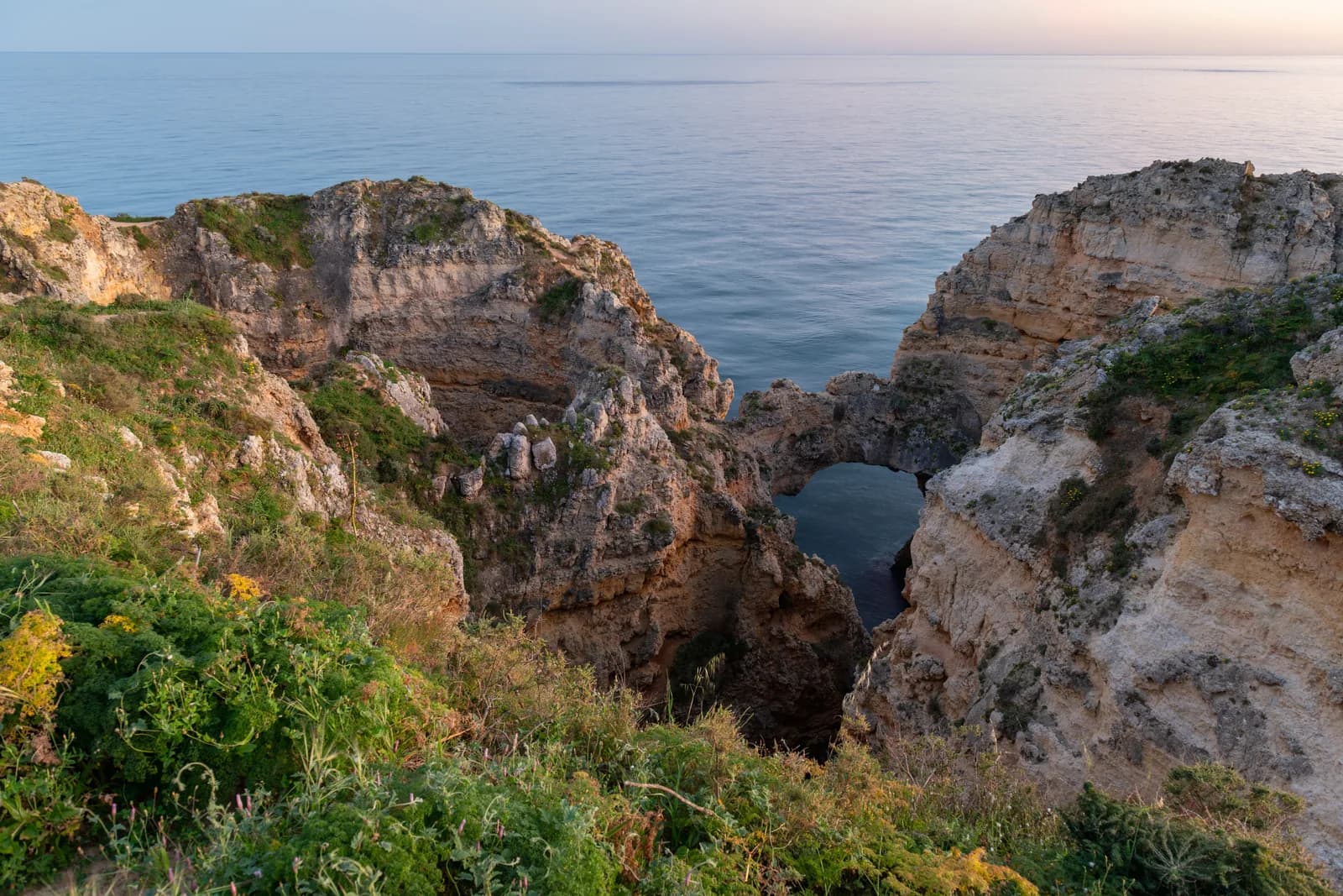 Sea arches and sandstone cliffs at Ponta da Piedade near Lagos, at dusk on the western Algarve coast