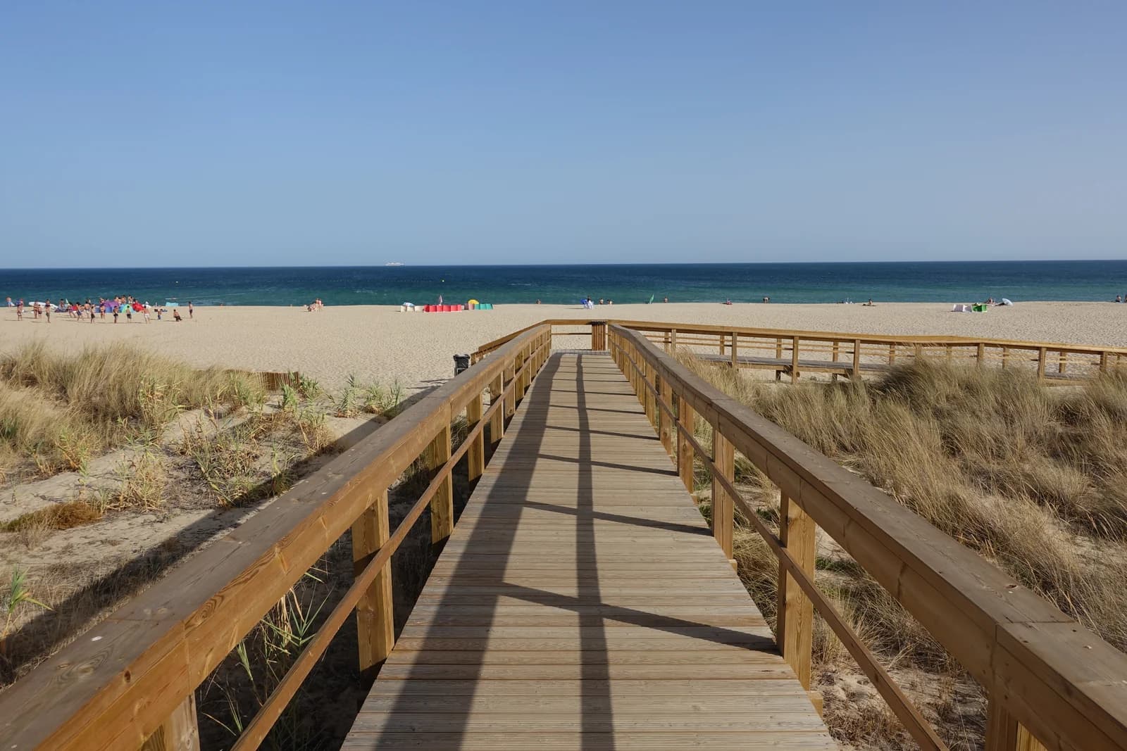 A wooden boardwalk over the dunes to the sand of Meia Praia, the long beach east of Lagos