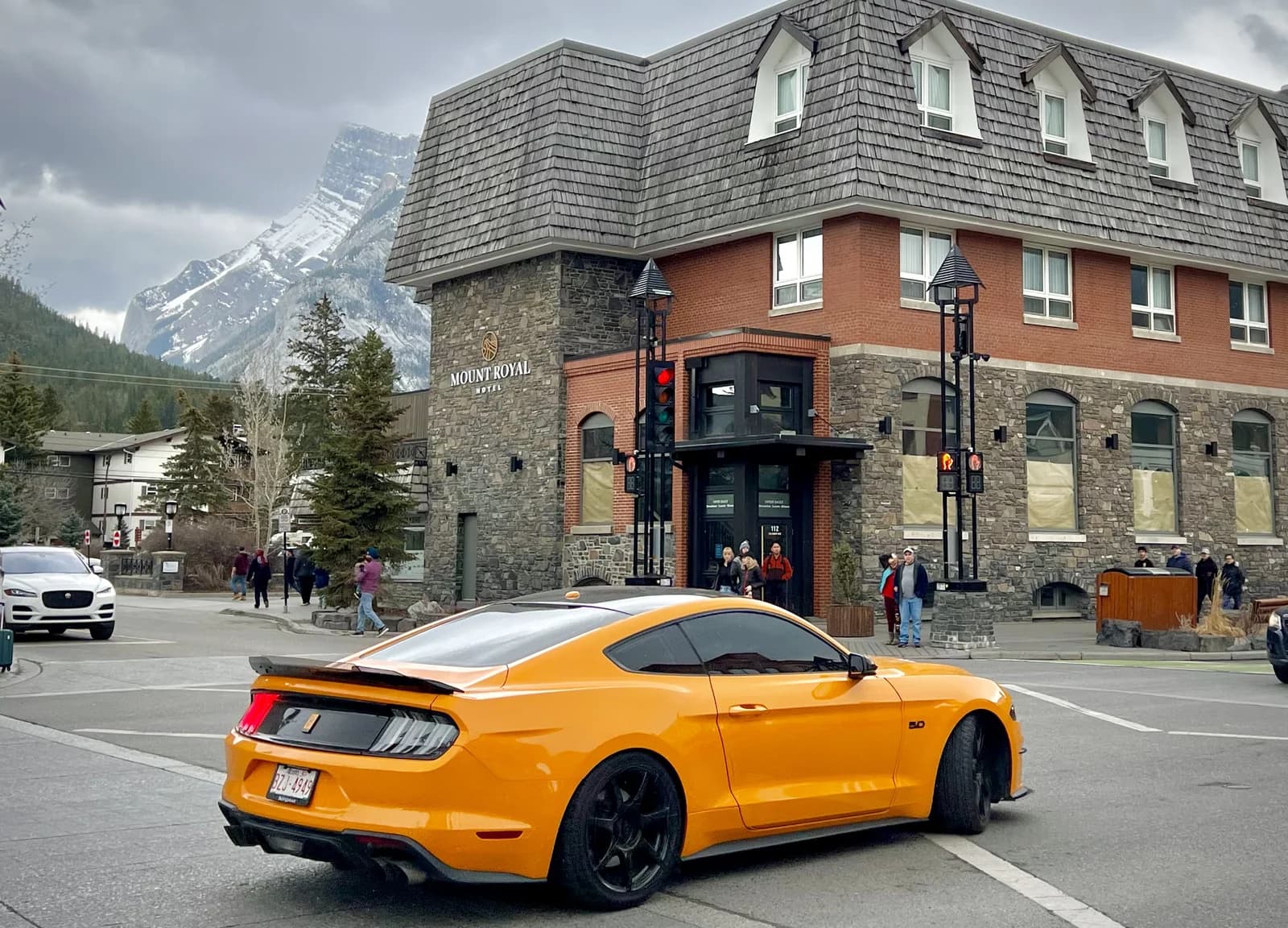 A corner shopfront on the downtown block of Banff Avenue with a parked car outside