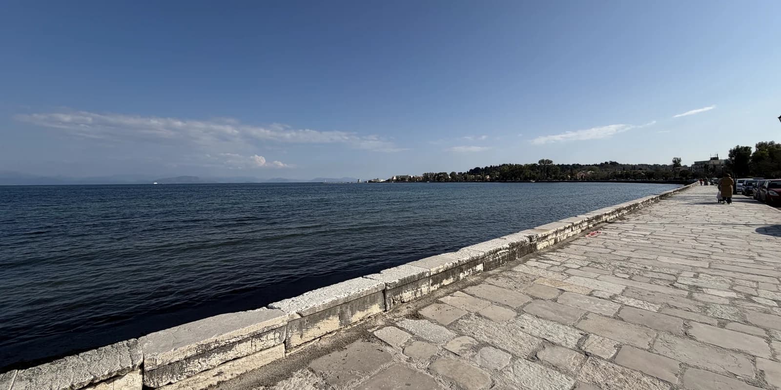 The stone seafront promenade on Garitsa Bay in Corfu Town, the bay the Anemomylos hotels look across