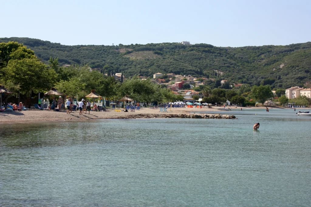 The shingle beach at Moraitika on Corfu's south-east coast, with the village on the green hillside behind