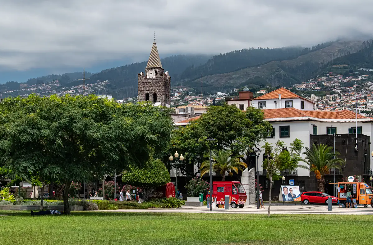 The Avenida do Mar seafront in central Funchal, with the cathedral tower and the city rising behind it