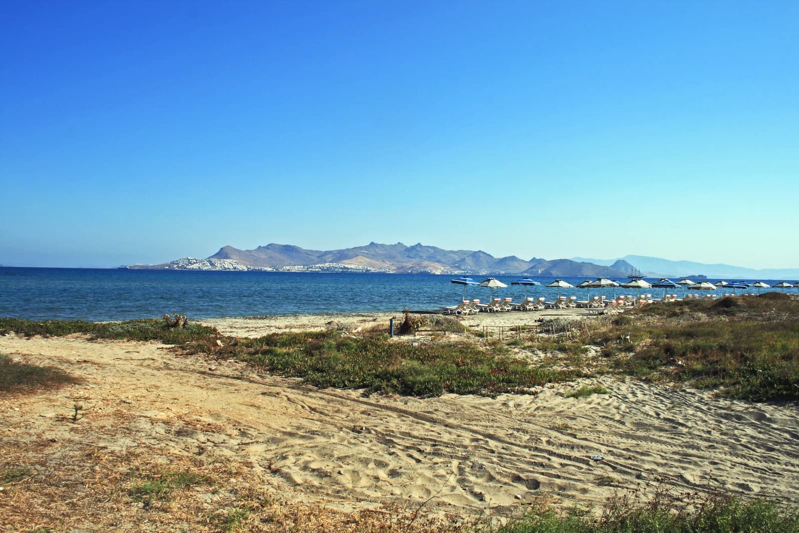 The sand and sunbeds of Lambi beach on the northern edge of Kos Town, with the Turkish coast across the water
