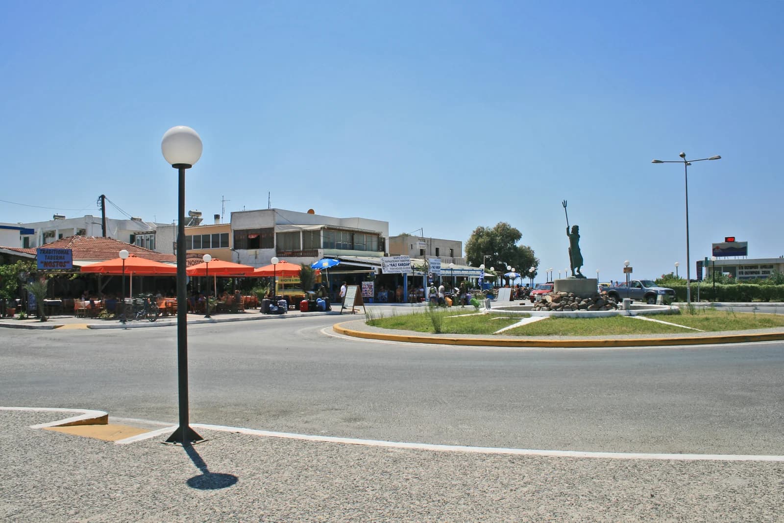 Tavernas and the Poseidon statue on the square in Mastichari, the fishing village on the north coast of Kos