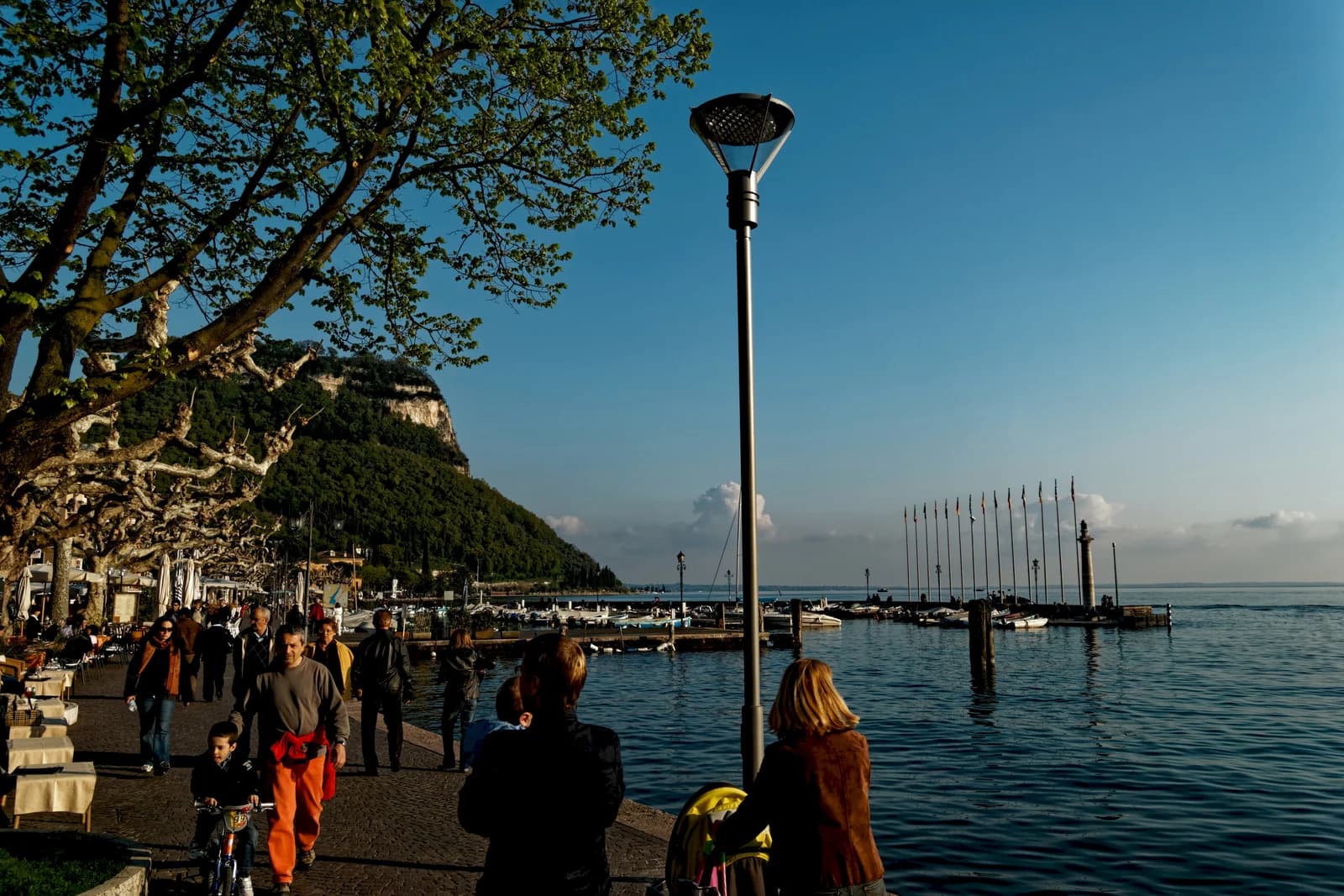 The Lungolago Regina Adelaide promenade in Garda town, with the Rocca di Garda headland behind