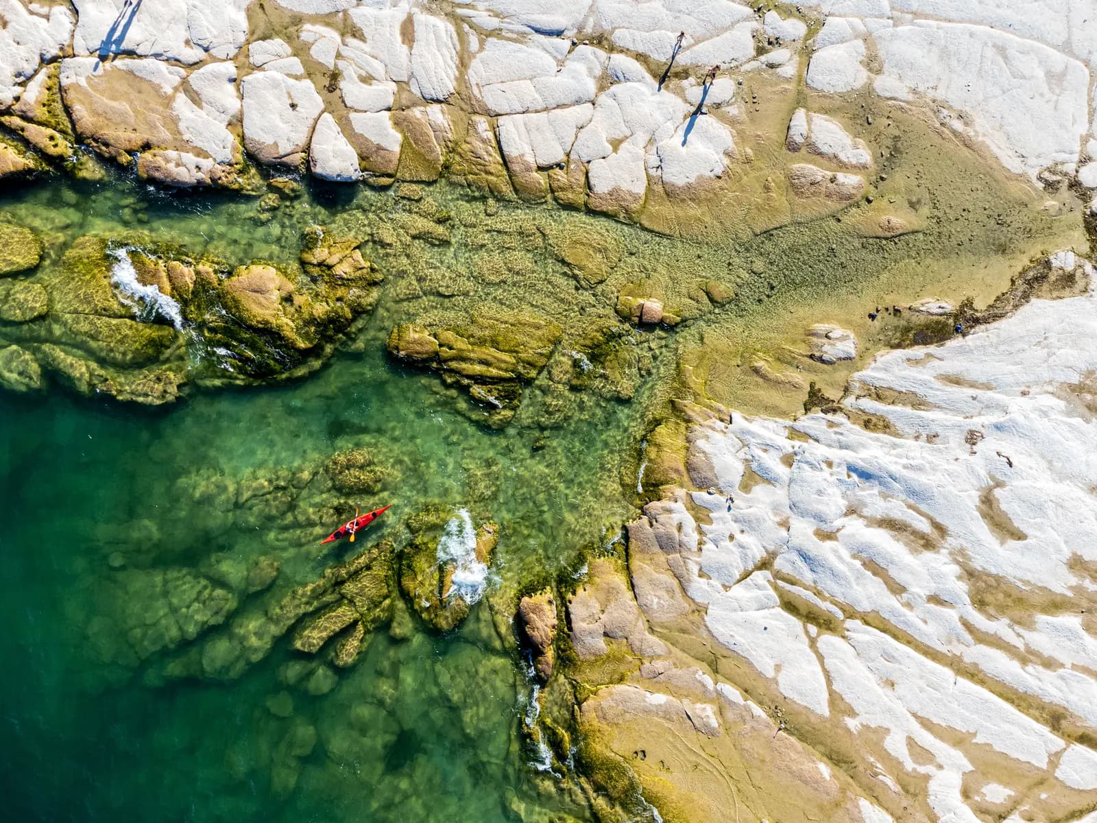 The limestone shelves and clear water of Jamaica Beach on the Sirmione peninsula, seen from above