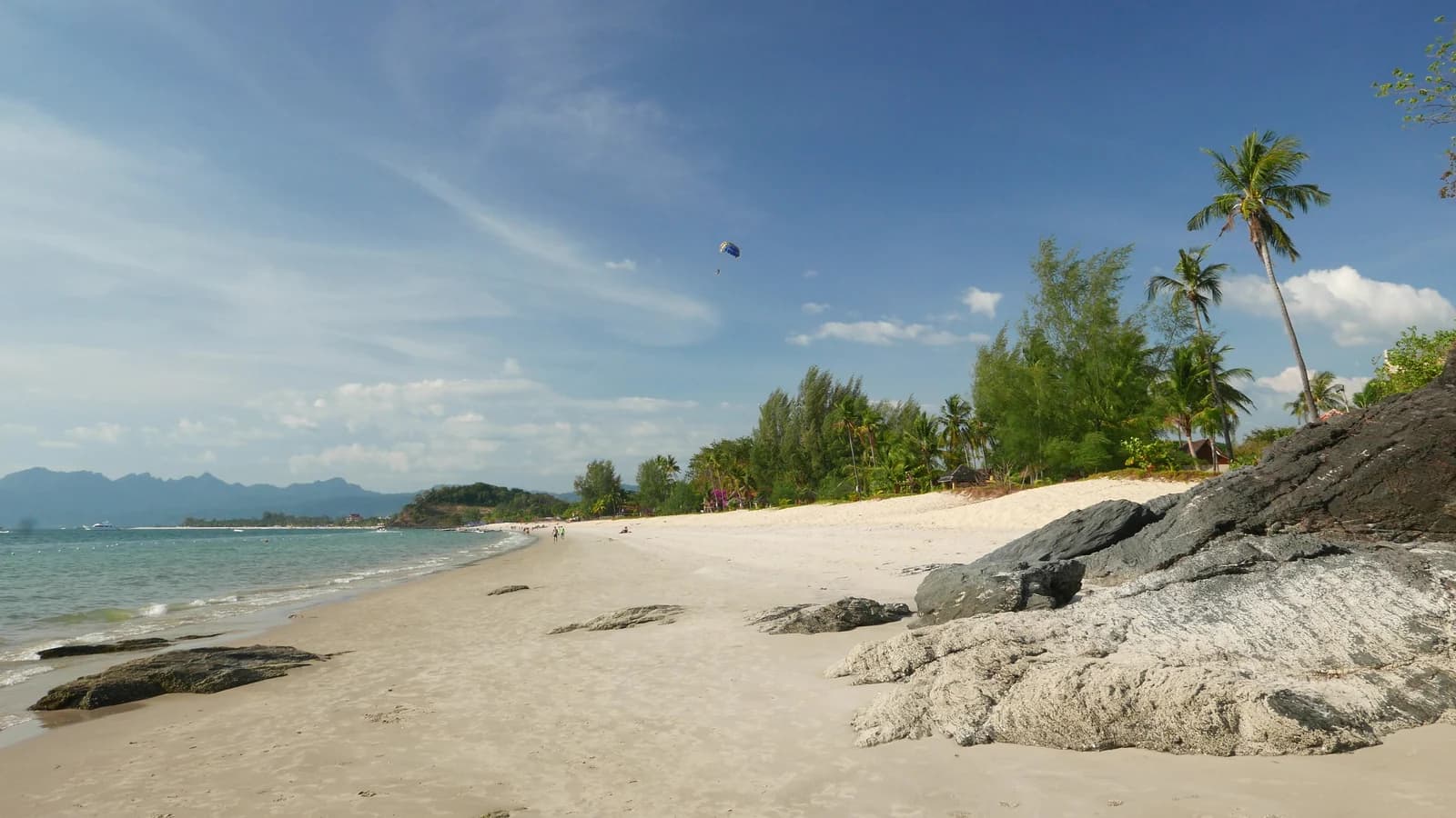 Granite boulders and palms on the sand at Pantai Cenang on the south-west coast of Langkawi
