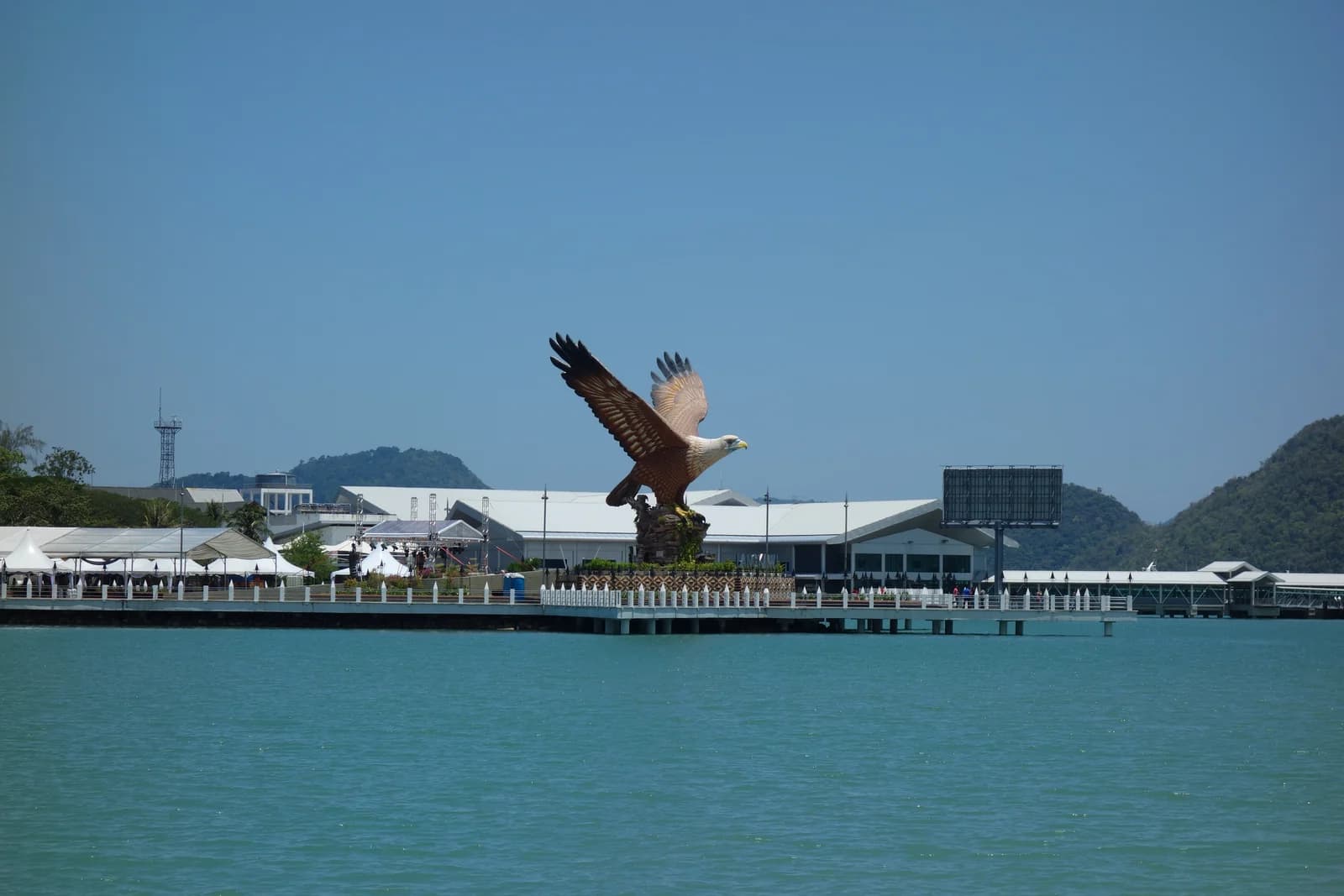 The Kuah waterfront in Langkawi seen from the bay, with the eagle statue beside the jetty buildings