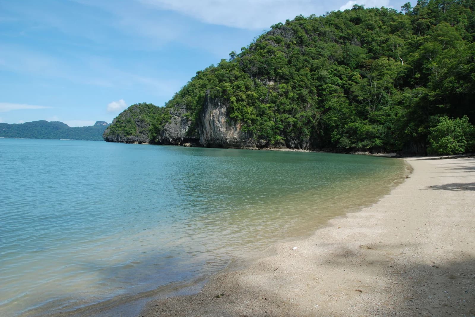 Clear shallow water below a limestone headland along the Tanjung Rhu shore in Langkawi