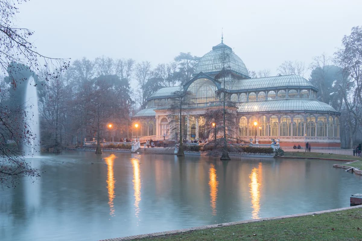 The Palacio de Cristal reflected in its pond in Madrid's Retiro park at dusk
