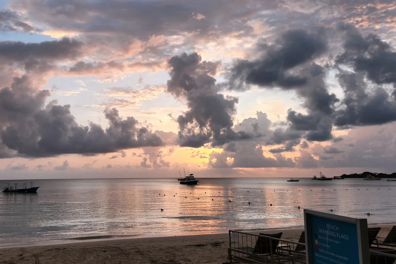 Evening cloud over the calm water off Negril beach, with boats moored offshore