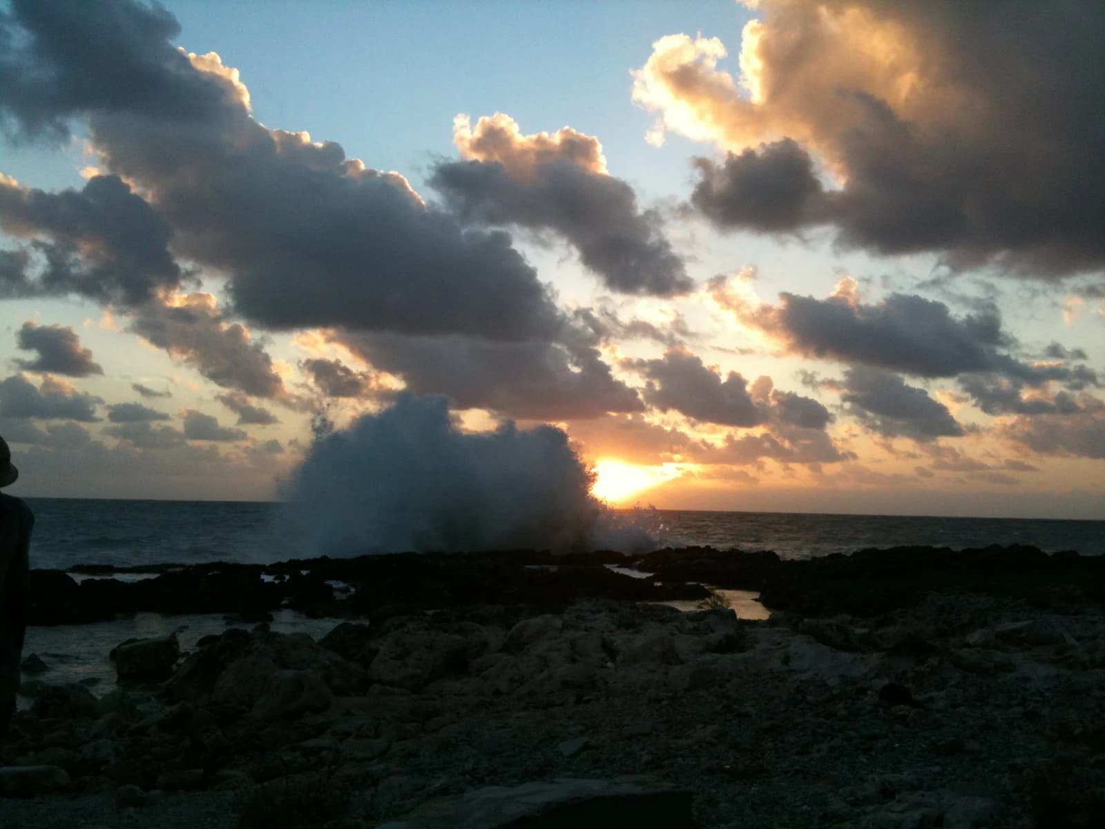 Surf breaking over the black limestone of Negril's West End cliffs at sunset