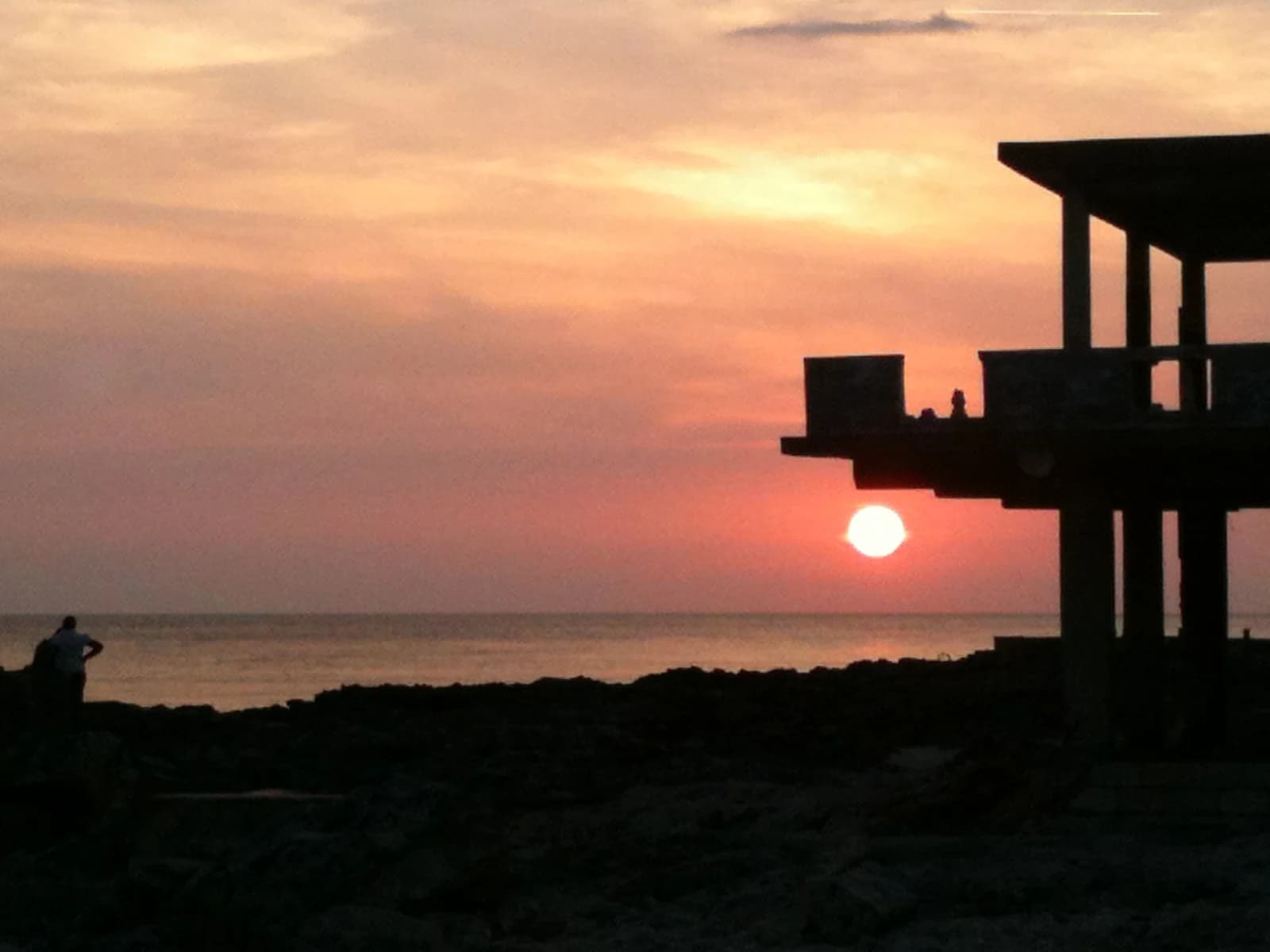 Sunset behind a concrete diving platform on the West End cliffs in Negril