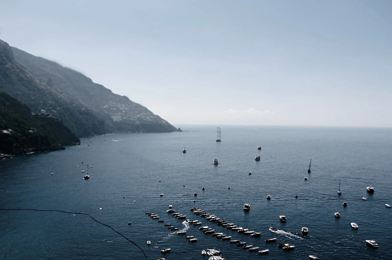 The lowest houses of Positano stacked directly above the water at the edge of the main beach