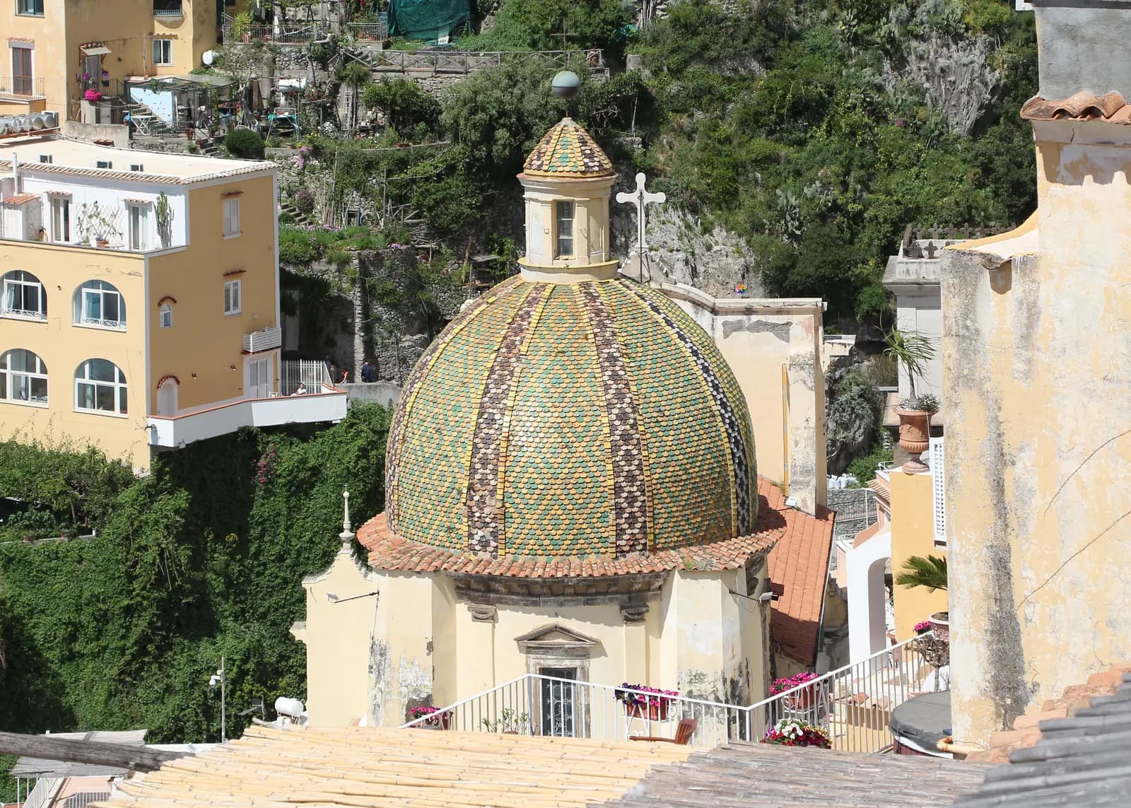 The majolica tiled dome of Santa Maria Assunta in the middle of Positano, with terraces stacked around it