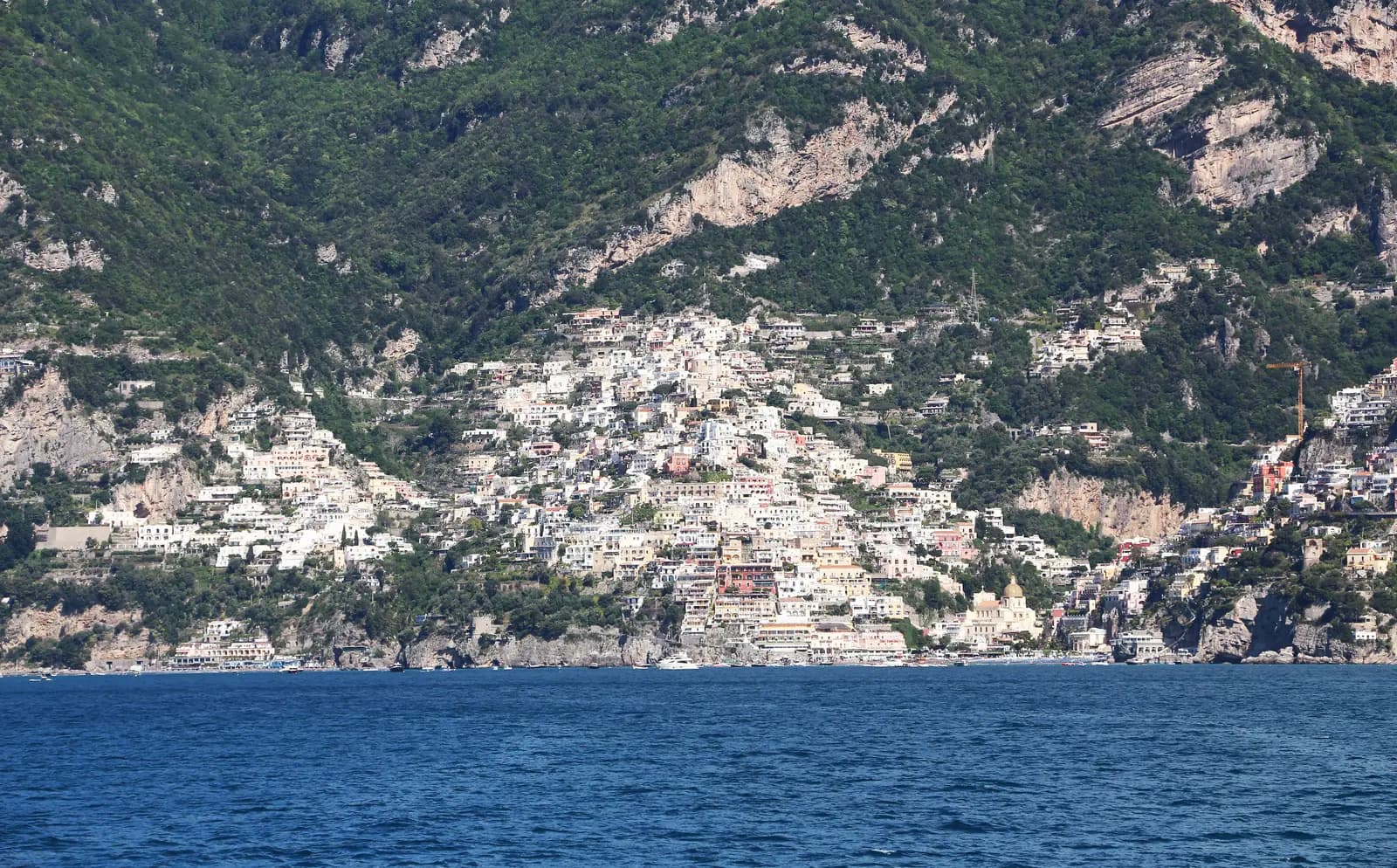 The full hillside of Positano from the water, showing how far the top of town sits above the beach