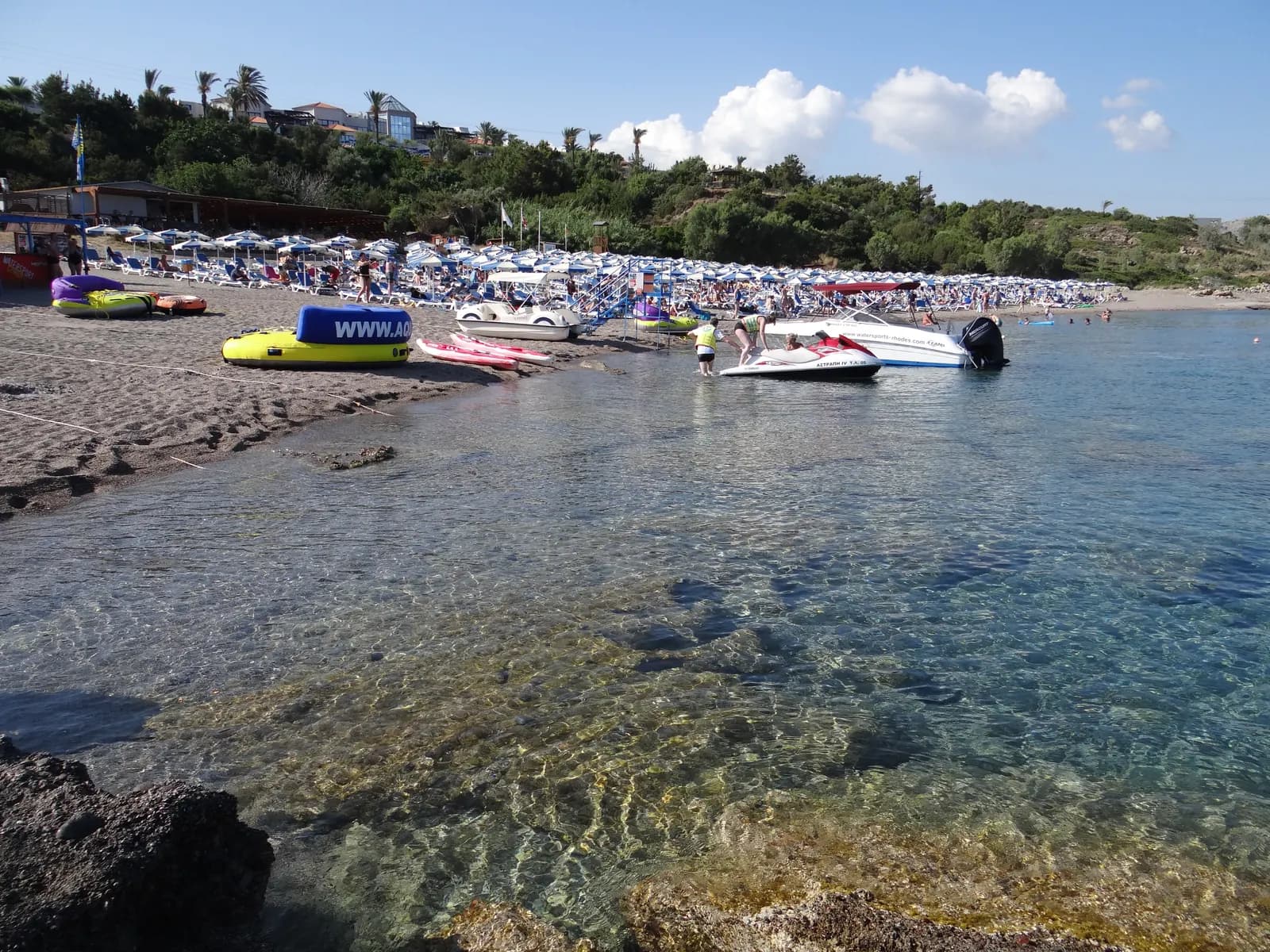 Clear shallow water and a row of sunbeds on the beach at Kiotari, on the south-east coast of Rhodes