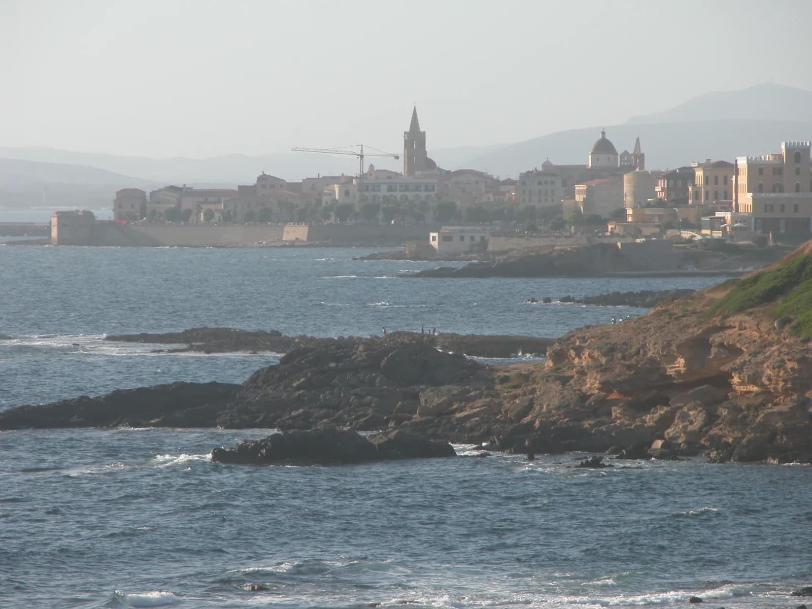 Alghero's old town seen across the rocky shore on the southern side of the town