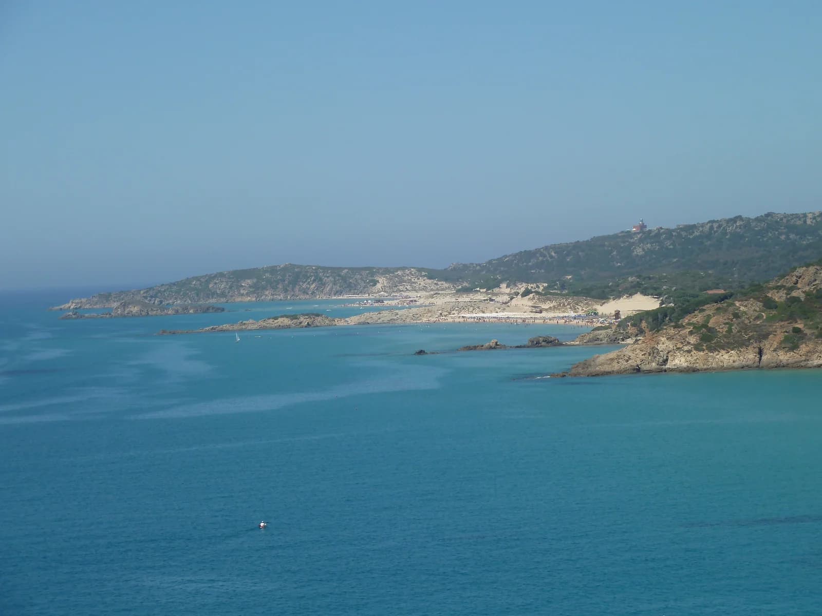 The coastline seen from Chia, with pale headlands running out into a blue sea in southern Sardinia