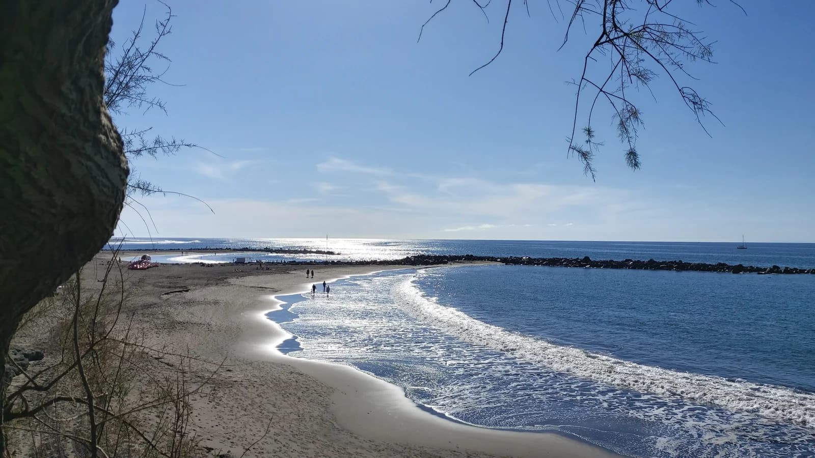 Playa de Troya, the grey-sand beach behind a breakwater at the Adeje end of Playa de las Américas