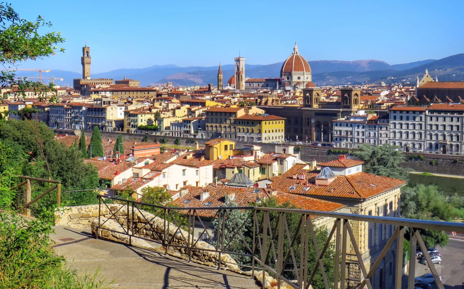 Florence seen across the rooftops of the historic centre, the ribbed dome of the cathedral and the tower of Palazzo Vecchio rising above a terracotta roofline