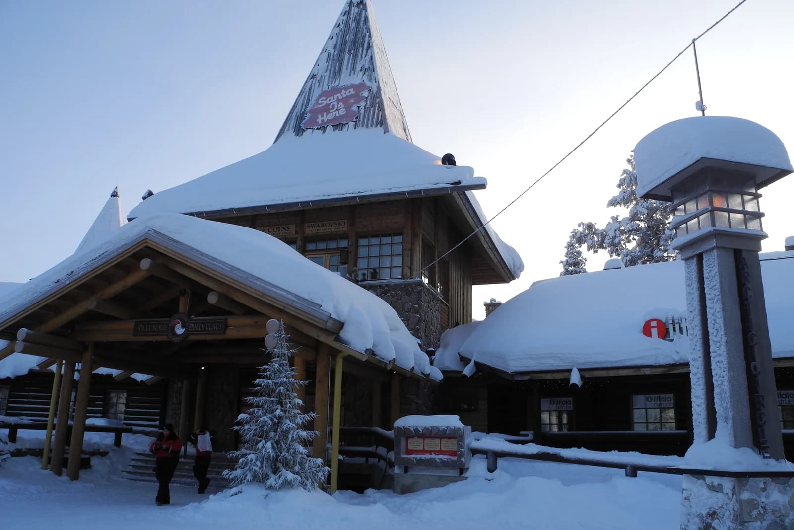 A snow covered wooden building at Santa Claus Village in Rovaniemi on a winter afternoon