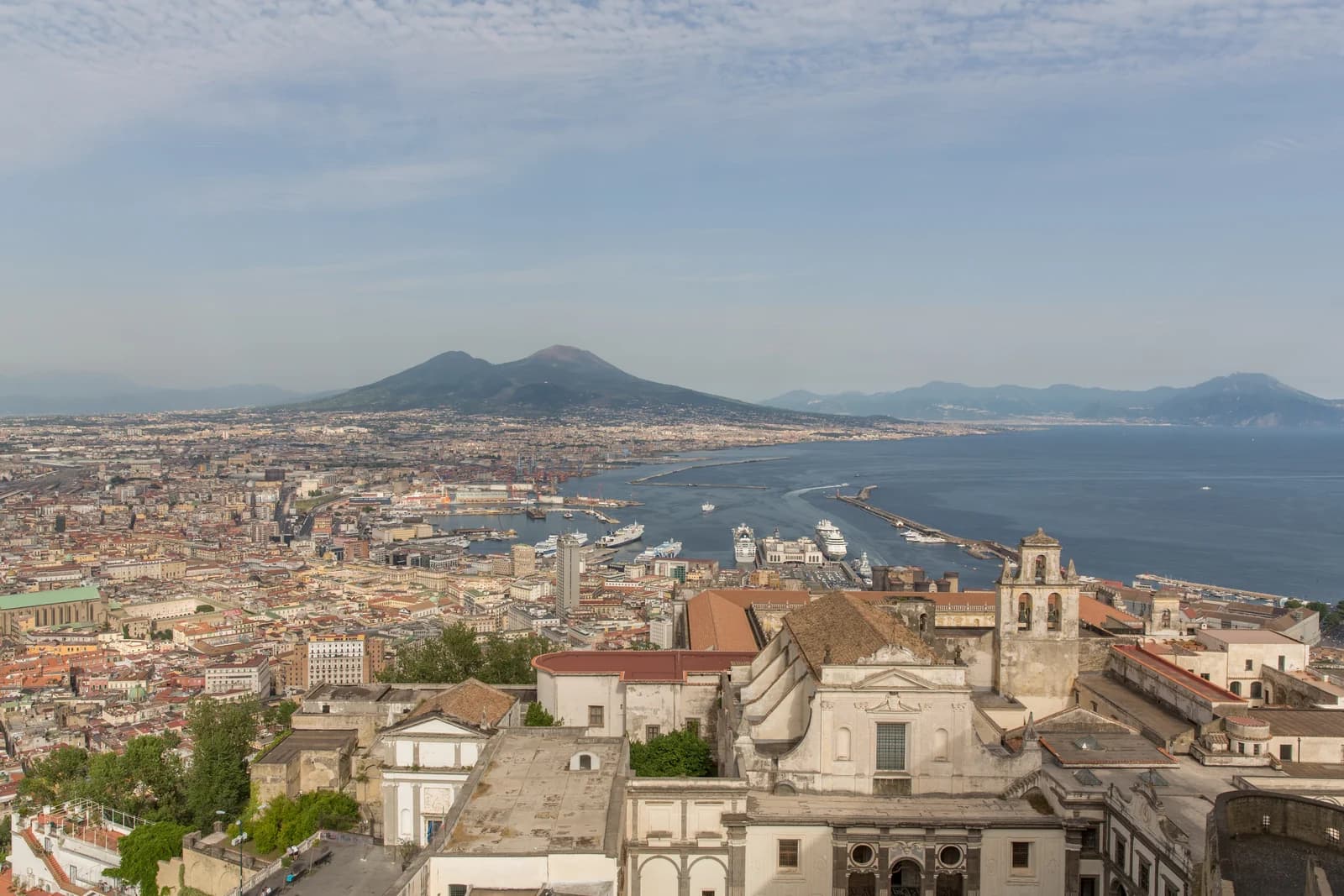 Naples seen from the hill at Castel Sant Elmo, the dense city spreading down to the bay with Vesuvius rising beyond it