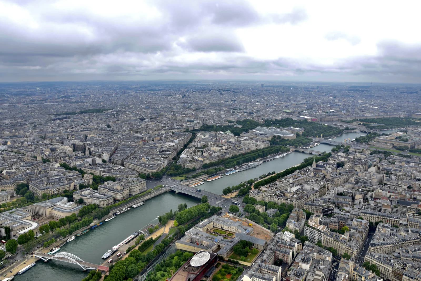 The Seine curving through Paris seen from high above, bridges crossing the river between dense blocks of pale stone buildings