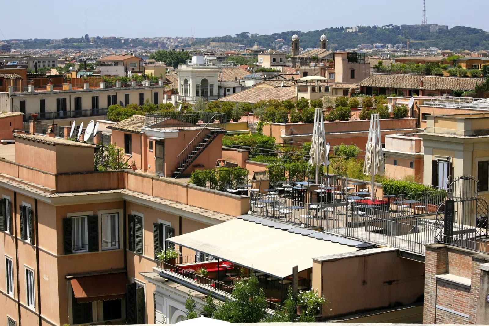Roof terraces and planted balconies above the rooftops of central Rome, where the city's hotel pools are built