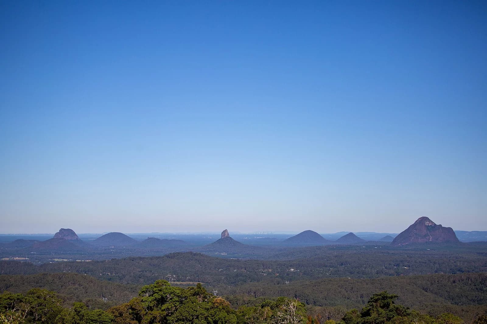The volcanic peaks of the Glass House Mountains rising out of farmland in the Sunshine Coast hinterland