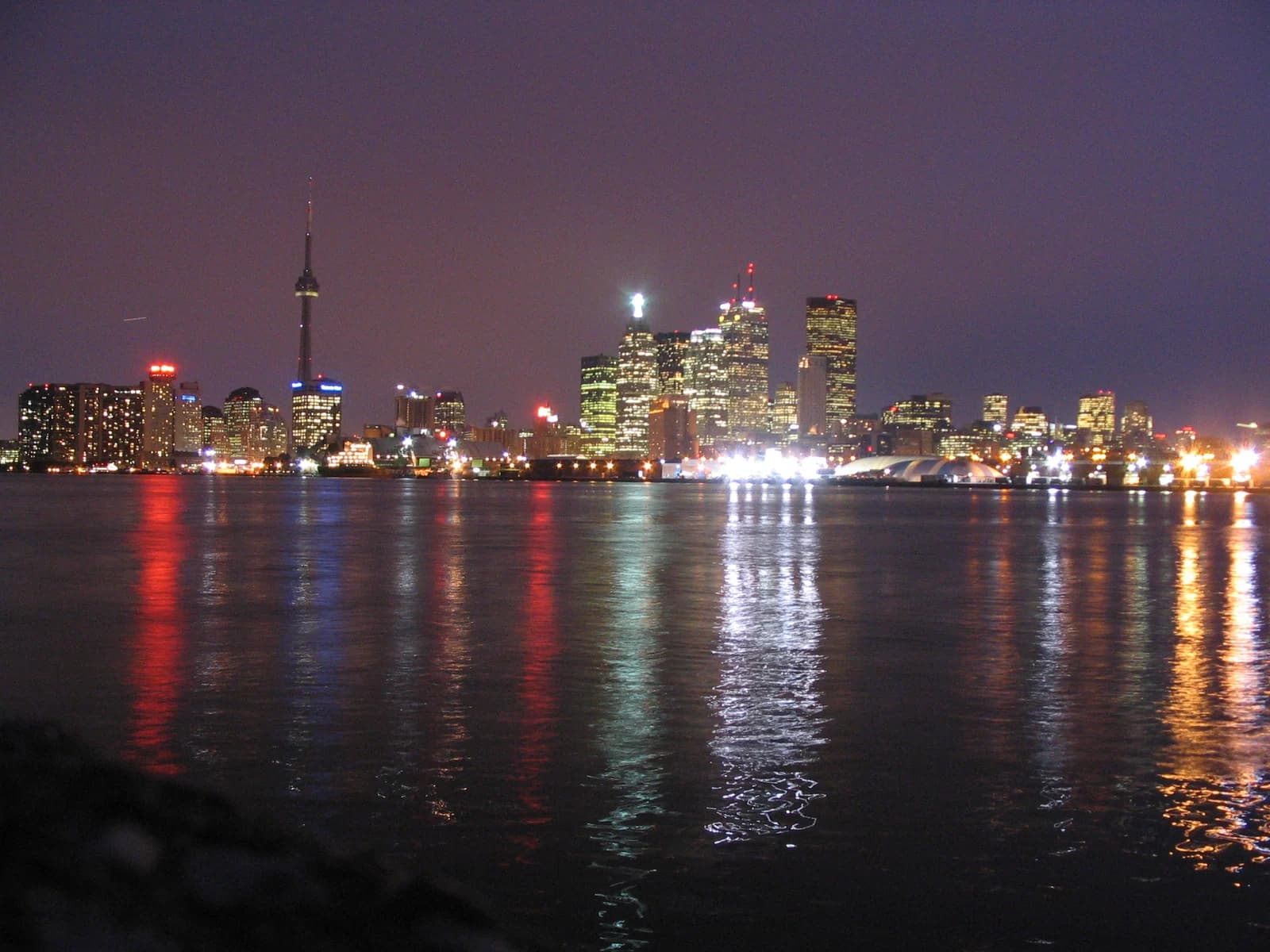 Toronto's skyline lit at night across the harbour, the city these family hotels sit in