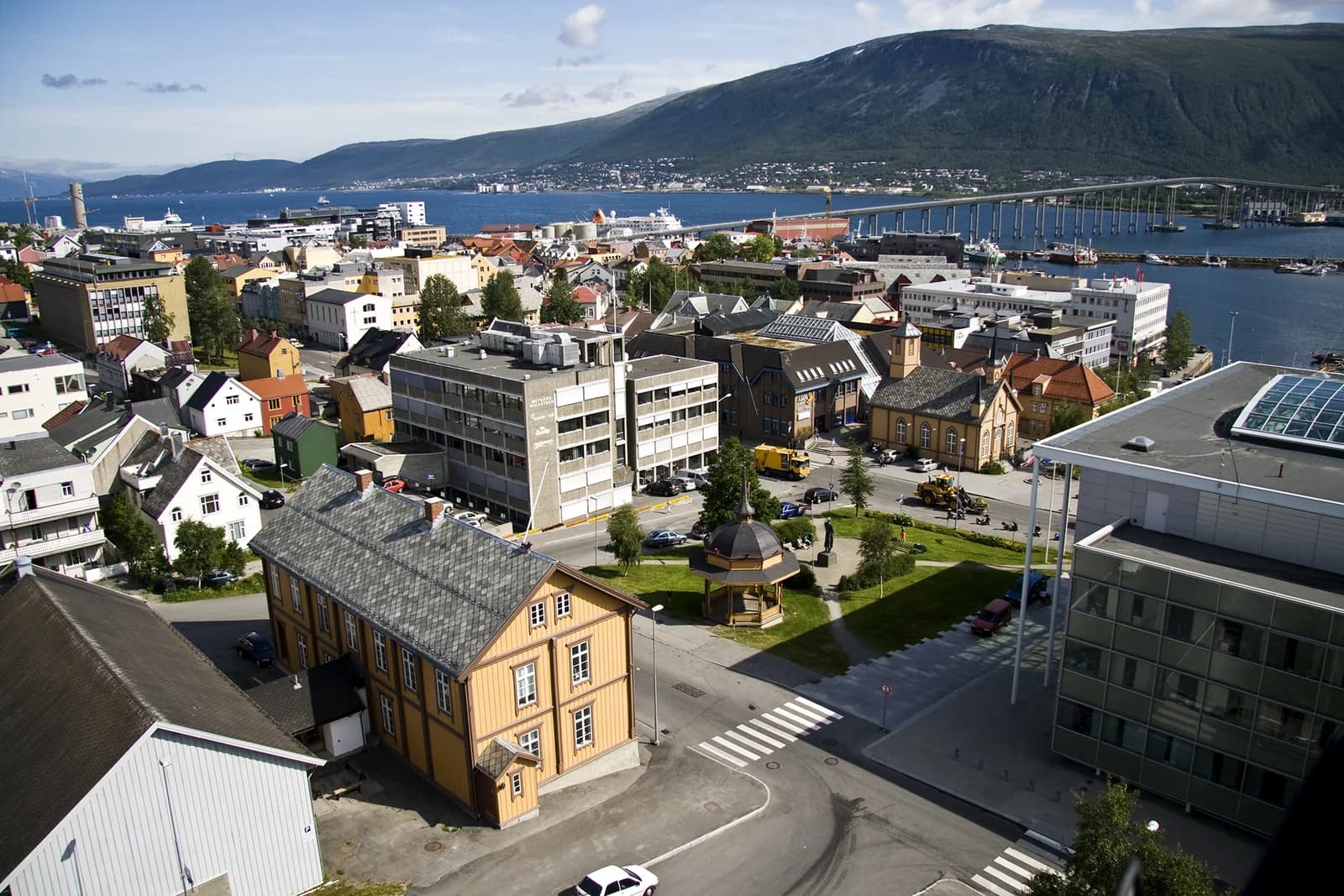 An elevated view over the Tromso town centre, its coloured timber houses and the bridge beyond