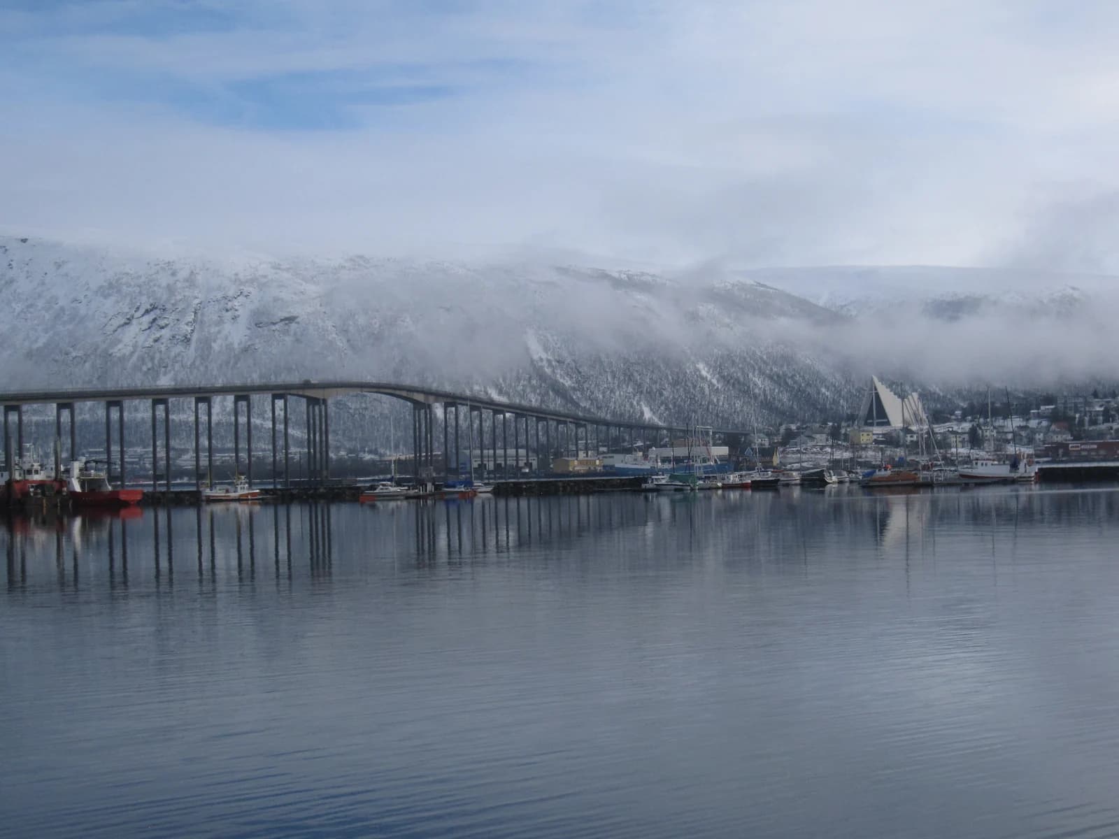 The Tromso bridge and the Arctic Cathedral seen across the sound from the harbour side of the city