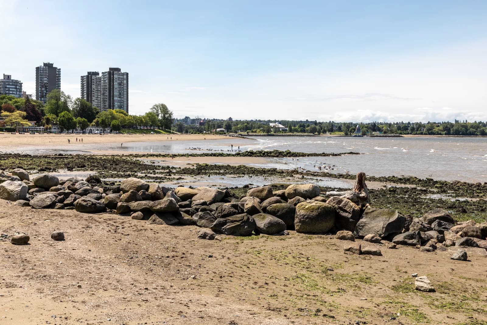 English Bay Beach at low tide with the West End towers behind, the setting for Vancouver's family hotels