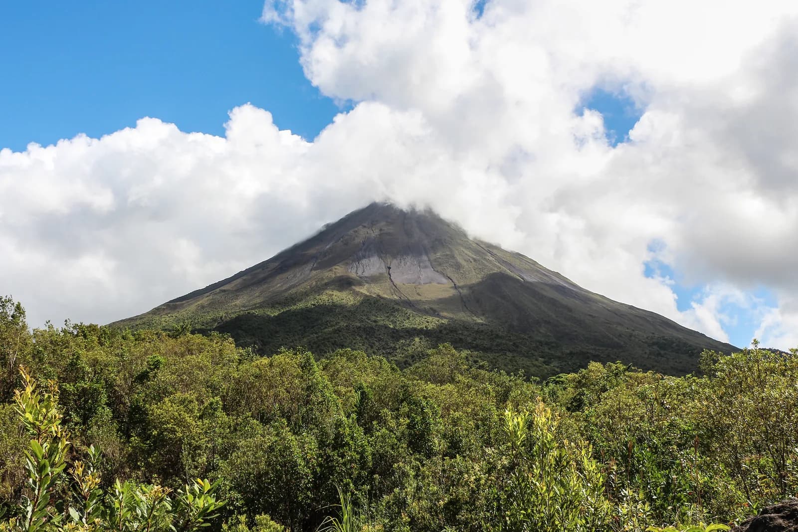 Arenal Volcano's symmetrical cone rising above lush rainforest in Costa Rica