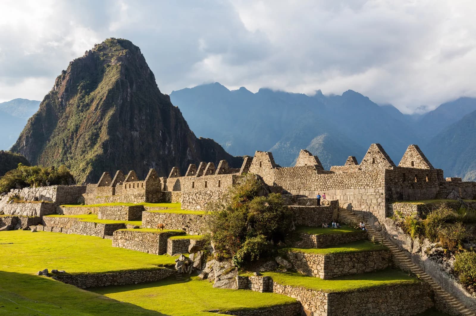 Machu Picchu Inca ruins with the Huayna Picchu peak rising behind in golden light