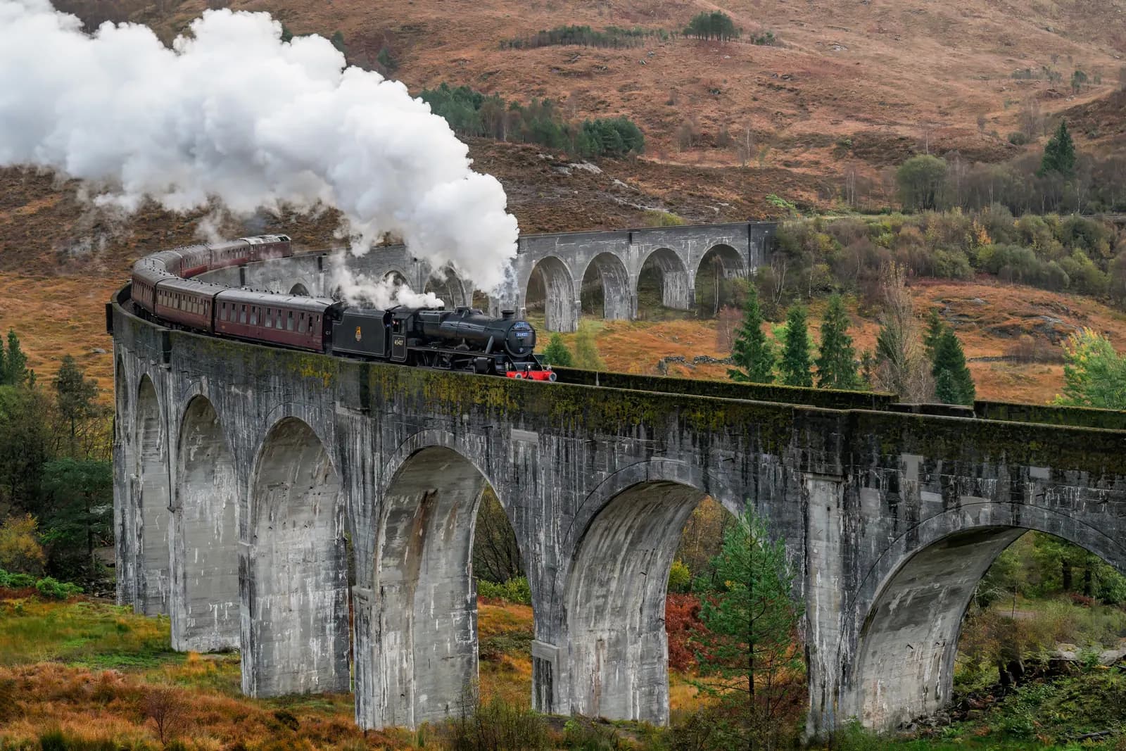 Jacobite steam train crossing the Glenfinnan Viaduct in the Scottish Highlands
