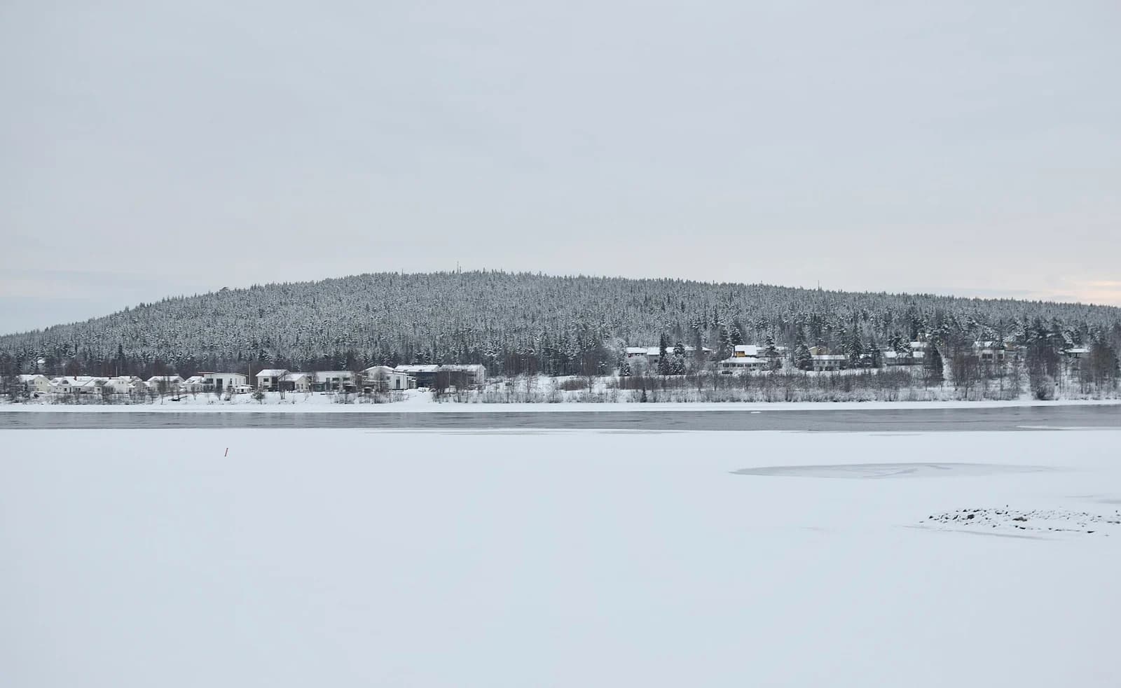 The snow-covered Ounasvaara fell and forest across the Ounasjoki river at Rovaniemi in winter
