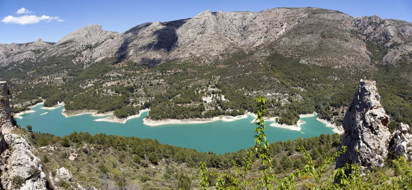 The turquoise Guadalest reservoir surrounded by steep mountains inland from the Costa Blanca, Alicante