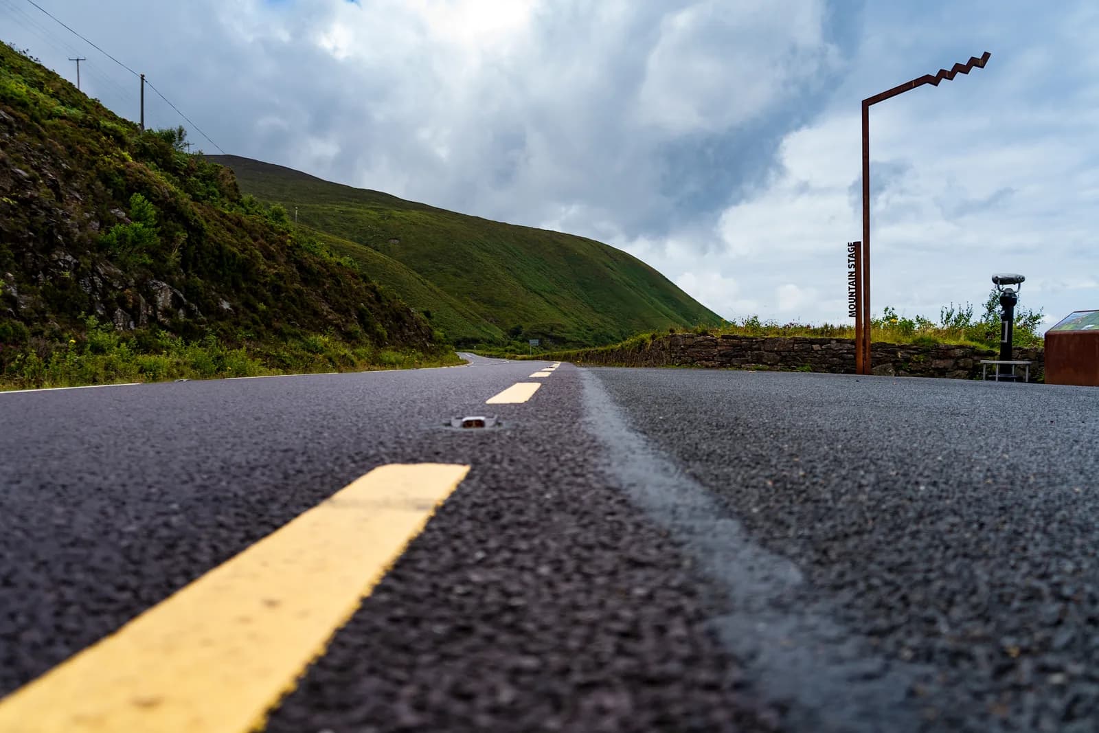 The Wild Atlantic Way road curving toward a green Irish mountain