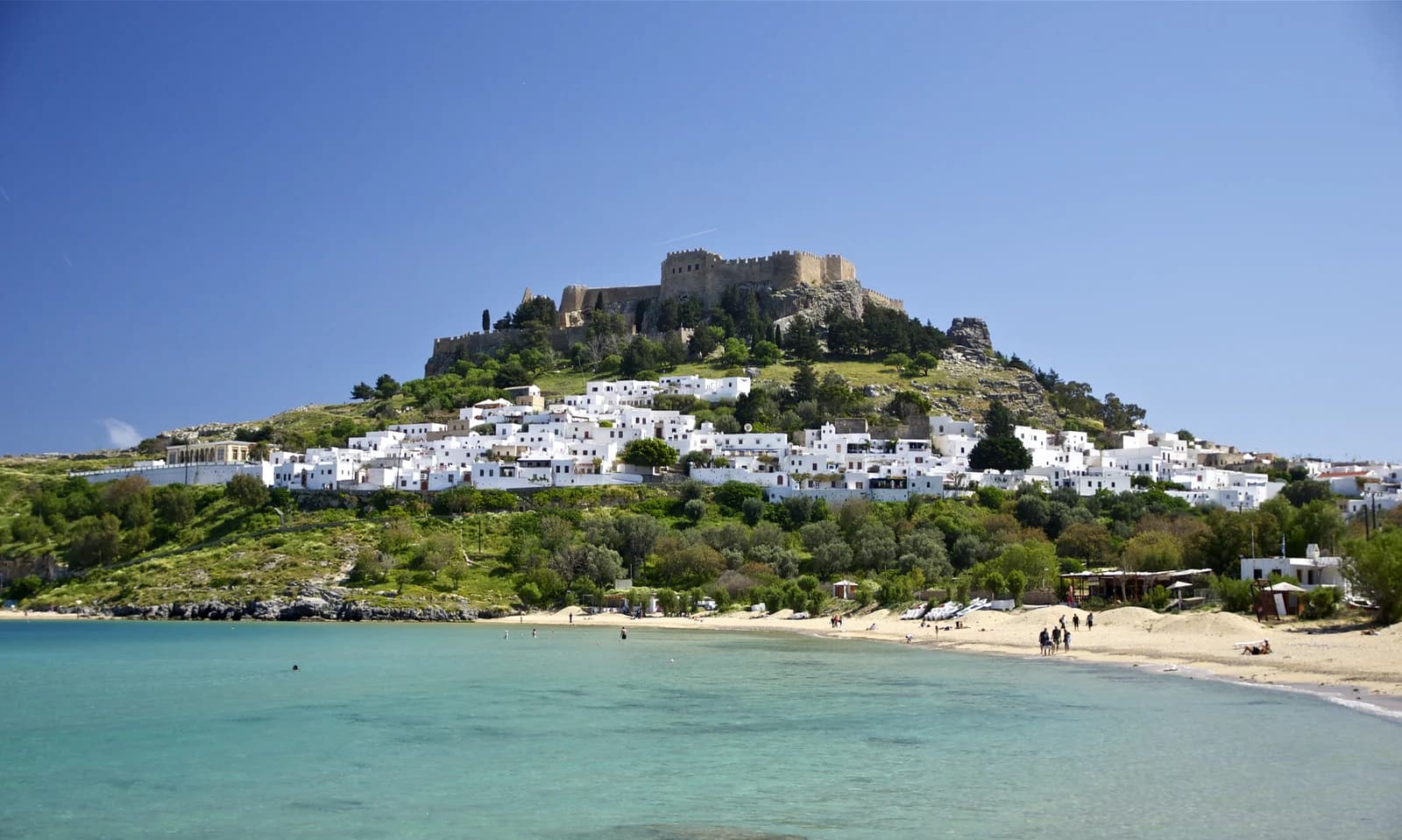 Lindos bay and the acropolis rock on Rhodes' sheltered east coast under summer sun